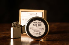 Stainless steel beard balm tin with silver lighter alongside and brown box in the background