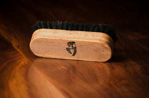 Wooden beard brush with logo on wooden surface