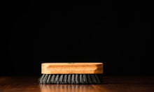 Beard brush positioned on a wooden surface