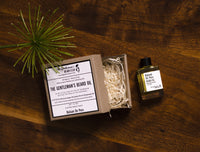Brown beard oil box laying open on a wooden surface with a bottle alongside it