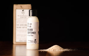Bottle of beard softener standing upright with a box in the background