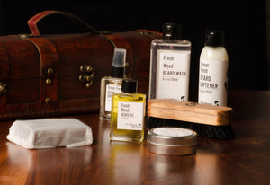 A variety of beard grooming kit products on display with a wooden box in the background